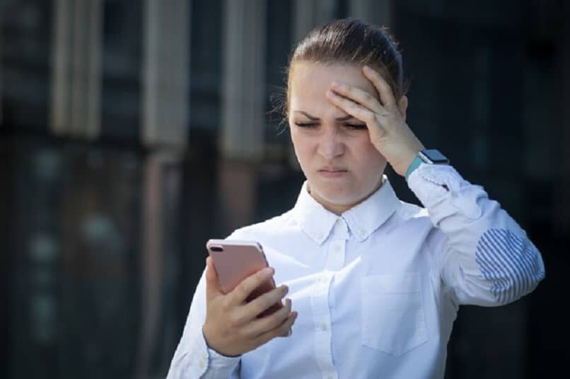 mujer frustrada mirando su celular