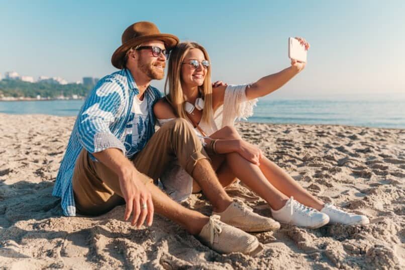 hombre-mujer-playa-tomando-selfie-foto_13163-5934366