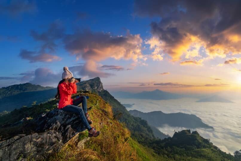 traveler-holding-camera-mountains_13163-2693078